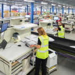 Packing stations are positioned alongside the conveyors at boohoo.com