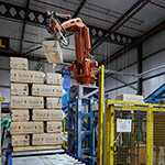 SCA Wood UK - Sawdust bales are stacked by a robotic arm before joining the conveyor line installed by BS Handling Systems